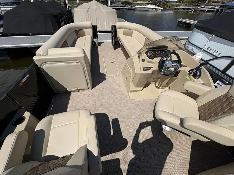 Slide: The Image of 2020 Crest Classic DLX 240 SLC pontoon boat interior with beige seating and steering console. - 9