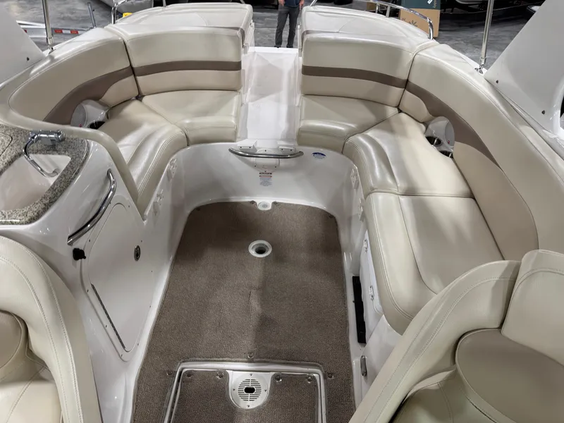 Slide: The Image of 2005 Chaparral 256 SSi boat interior with beige seating and carpeted floor. - 10