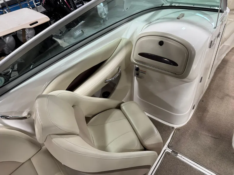 Slide: The Image of 2005 Chaparral 256 SSi boat interior with beige seating and dashboard. - 12