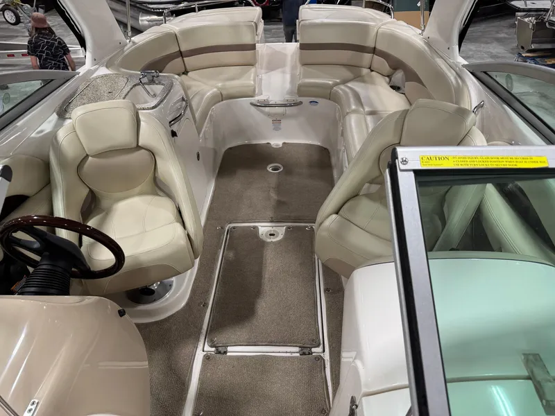 Slide: The Image of 2005 Chaparral 256 SSi boat interior with beige seating and carpeted flooring. - 7