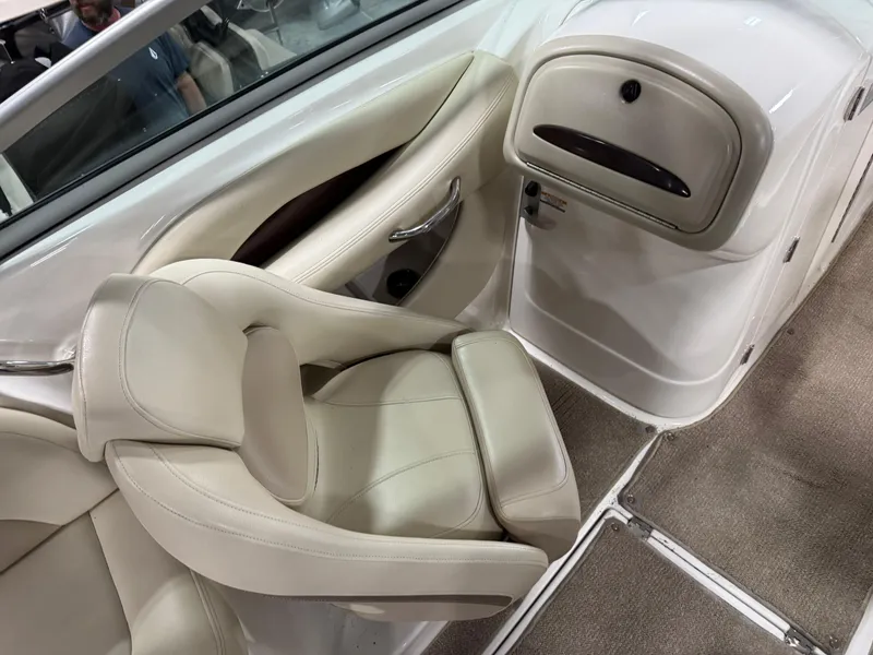 Slide: The Image of 2005 Chaparral 256 SSi boat interior with beige seating and carpeted flooring. - 8