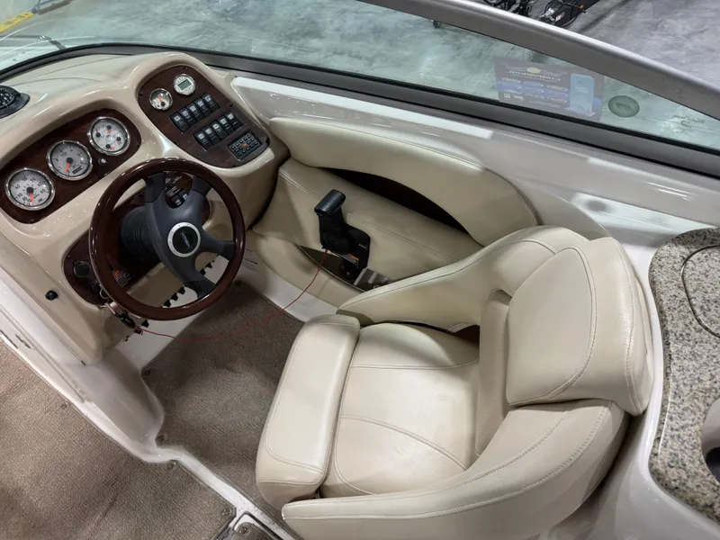 Slide: The Image of 2005 Chaparral 256 SSi boat interior with beige seating and dashboard controls. - 9