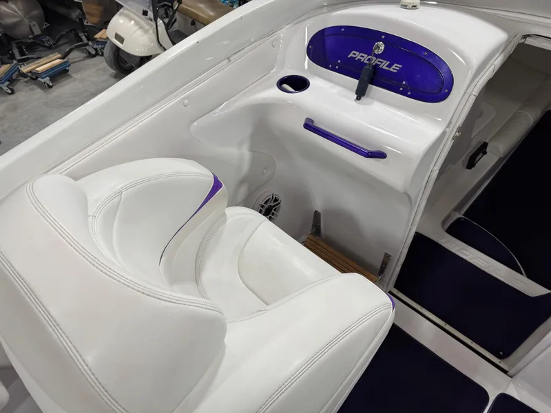 Slide: The Image of 2003 Profile 290 boat interior with white and purple seating and dashboard. - 11