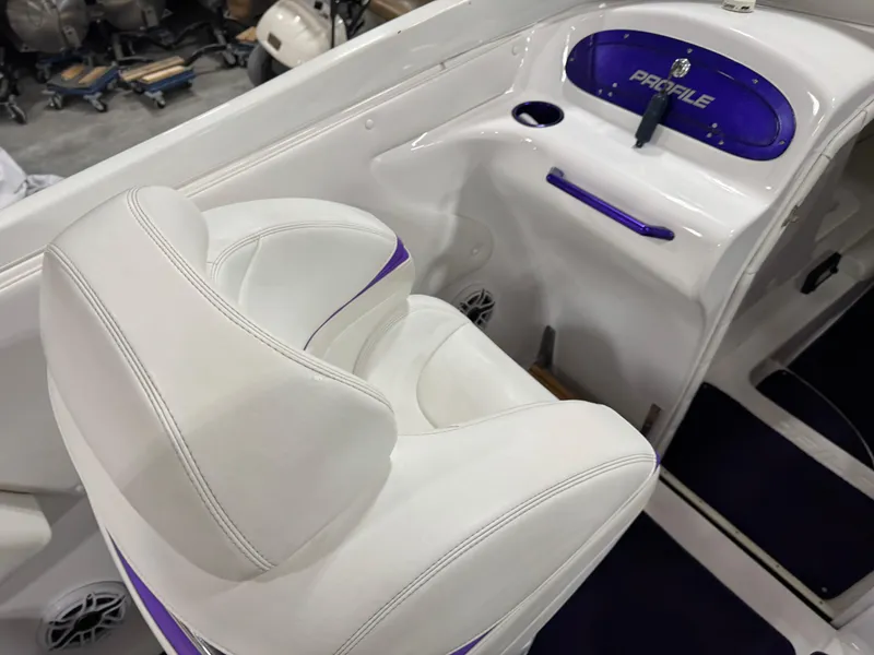 Slide: The Image of White and purple interior of a 2003 Profile 290 boat, featuring cushioned seating and dashboard. - 12