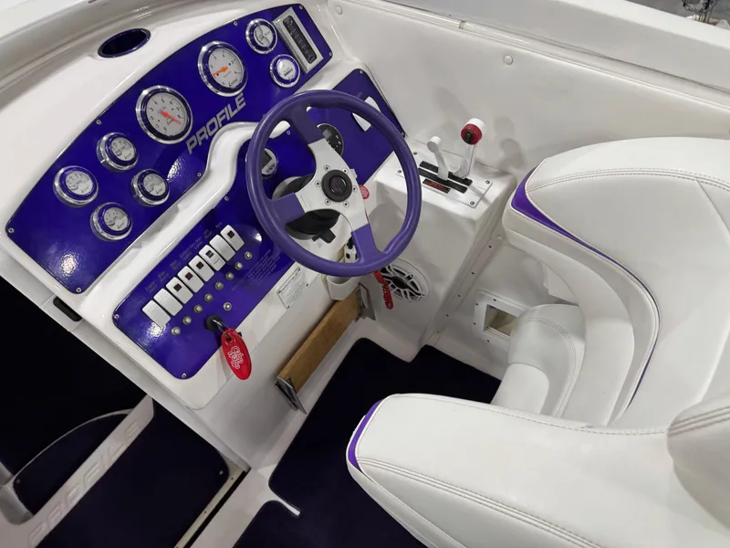 Slide: The Image of Cockpit of 2003 Profile 290 boat with purple steering wheel and gauges. - 13