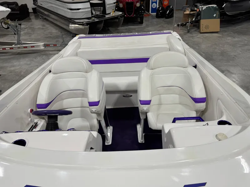 Slide: The Image of 2003 Profile 290 boat interior with white and purple seating in a showroom. - 17