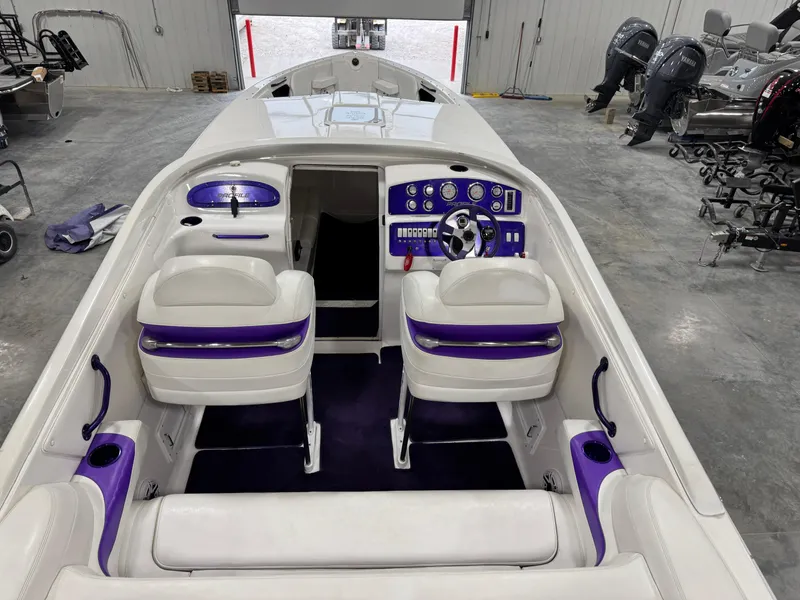 Slide: The Image of 2003 Profile 290 boat interior with white and purple seating, sleek dashboard, and modern controls. - 7