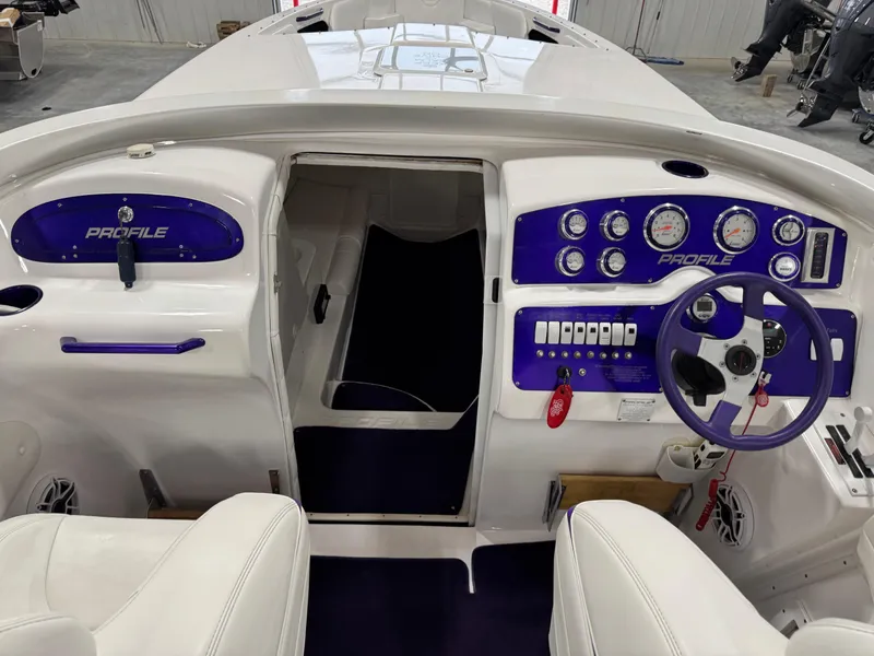 Slide: The Image of 2003 Profile 290 boat cockpit with purple accents and modern dashboard controls. - 8