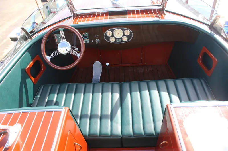 Slide: The Image of Interior of 2017 Hacker-Craft 30 boat with classic wooden dashboard and green seating. - 2