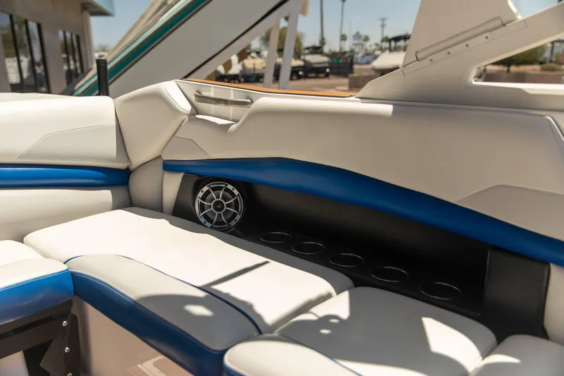 Slide: The Image of Interior of 2015 Axis 22 boat with white and blue seating, speaker, and cup holders. - 7