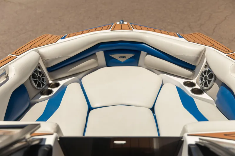 Slide: The Image of 2015 Axis 22 boat interior with white and blue seating, cup holders, and speakers. - 9