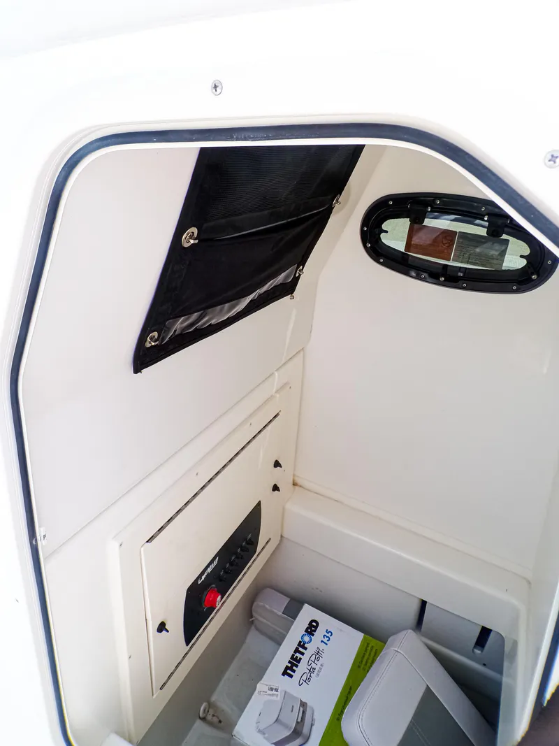 Slide: The Image of 2025 Mako 214CC boat interior storage compartment with window and equipment. - 10
