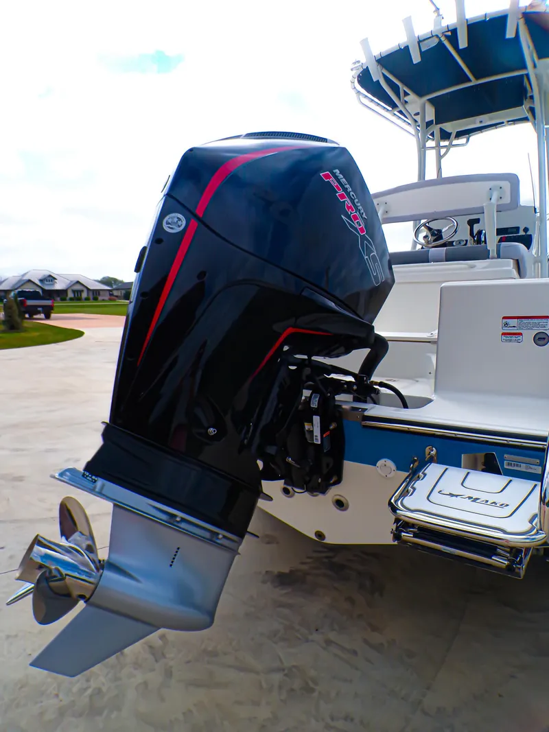 Slide: The Image of 2025 Mako 214CC boat with powerful outboard motor, docked on a sunny day. - 4