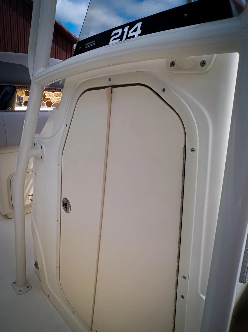 Slide: The Image of 2025 Mako 214CC boat cabin door, white exterior, sleek design. - 9
