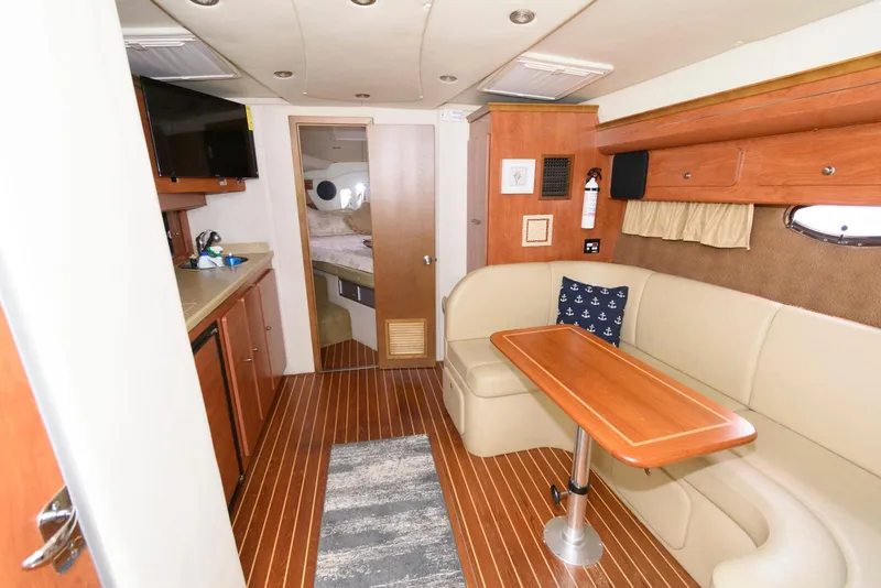 Slide: The Image of Interior of 2006 Rinker 390 Express Cruiser with seating, table, and kitchenette. - 12