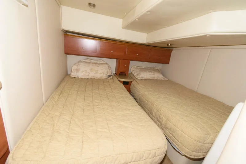 Slide: The Image of 2006 Rinker 390 Express Cruiser cabin with twin beds and beige bedding. - 16