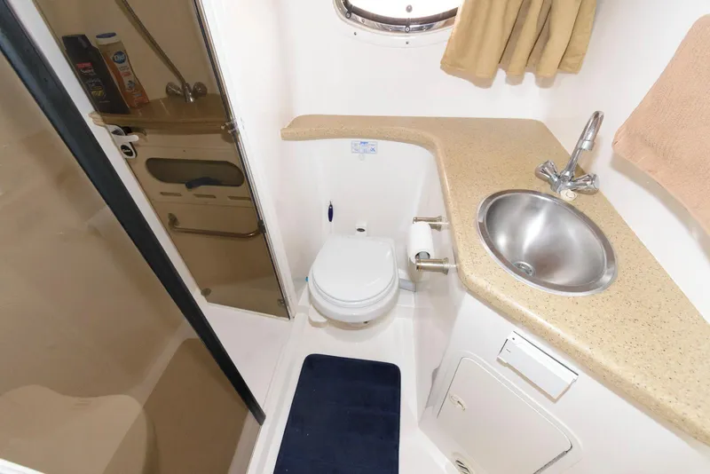 Slide: The Image of Bathroom interior of 2006 Rinker 390 Express Cruiser with sink, toilet, and shower. - 17