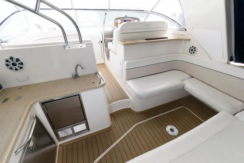 Slide: The Image of 2006 Rinker 390 Express Cruiser interior with seating, kitchenette, and wood flooring. - 4