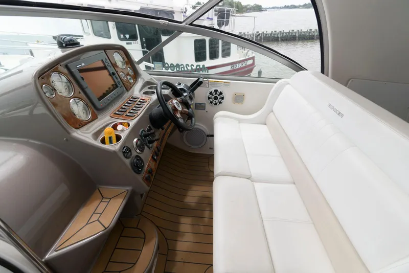 Slide: The Image of 2006 Rinker 390 Express Cruiser cockpit with white seating and modern control panel. - 8