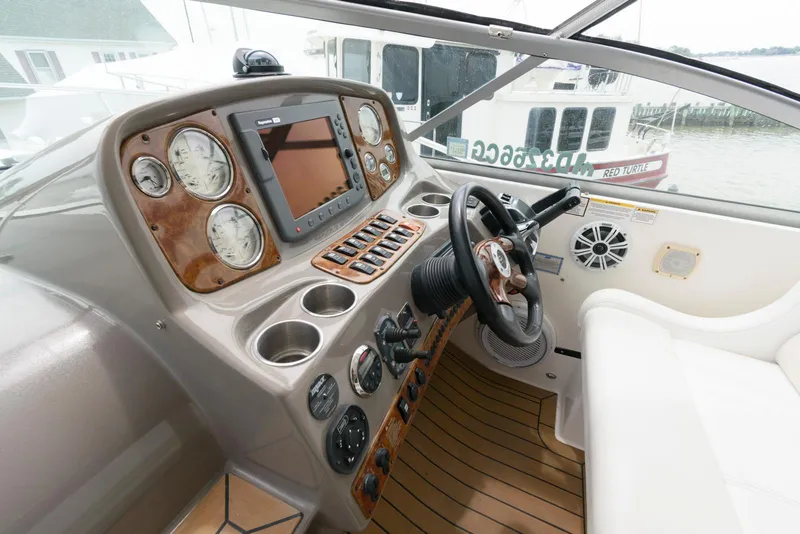 Slide: The Image of 2006 Rinker 390 Express Cruiser helm with gauges, steering wheel, and navigation system. - 9