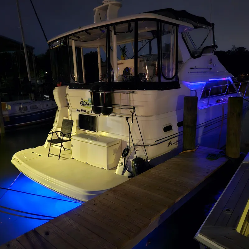Slide: The Image of 1999 Cruisers Yachts 3750 Motoryacht docked at night with blue underwater lights. - 13