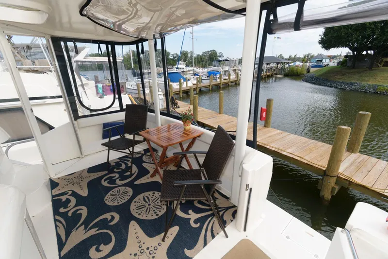 Slide: The Image of 1999 Cruisers Yachts 3750 Motoryacht deck with chairs, table, and marina view. - 4