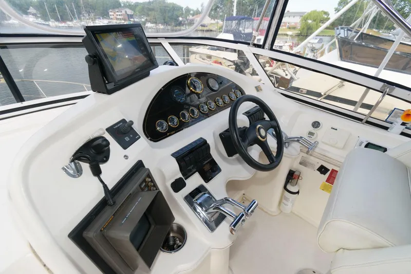 Slide: The Image of 1999 Cruisers Yachts 3750 Motoryacht helm with steering wheel and navigation controls. - 6