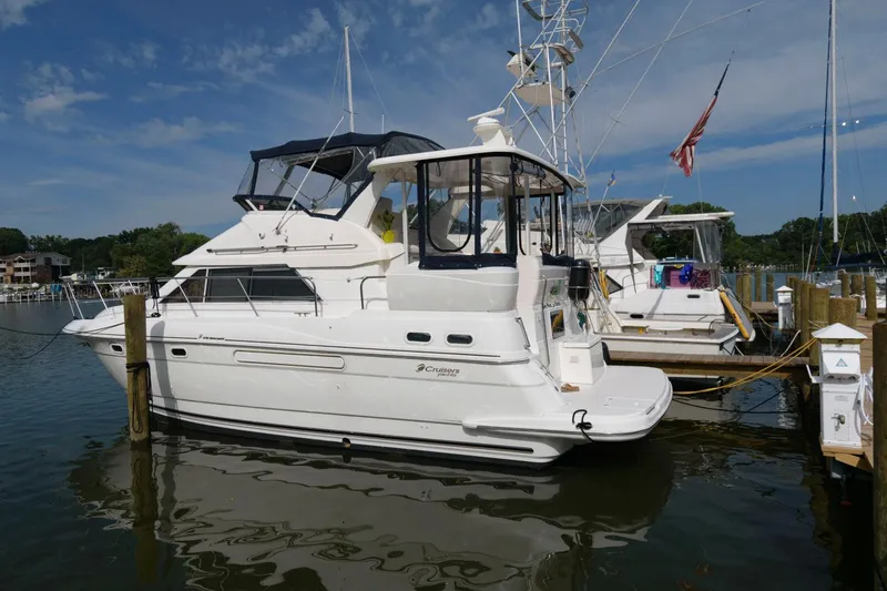 Slide: The Image of 1999 Cruisers Yachts 3750 Motoryacht docked in a marina under a clear sky. - 1