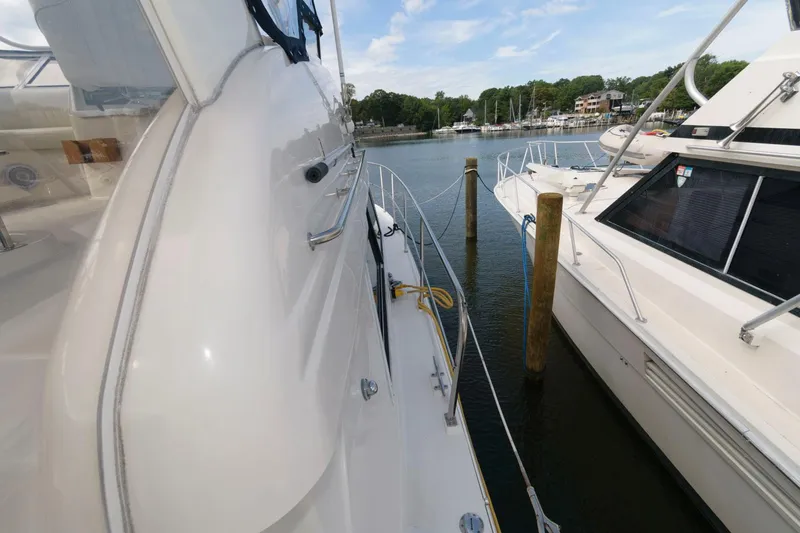 Slide: The Image of 1999 Cruisers Yachts 3750 Motoryacht docked beside another boat in a marina. - 11