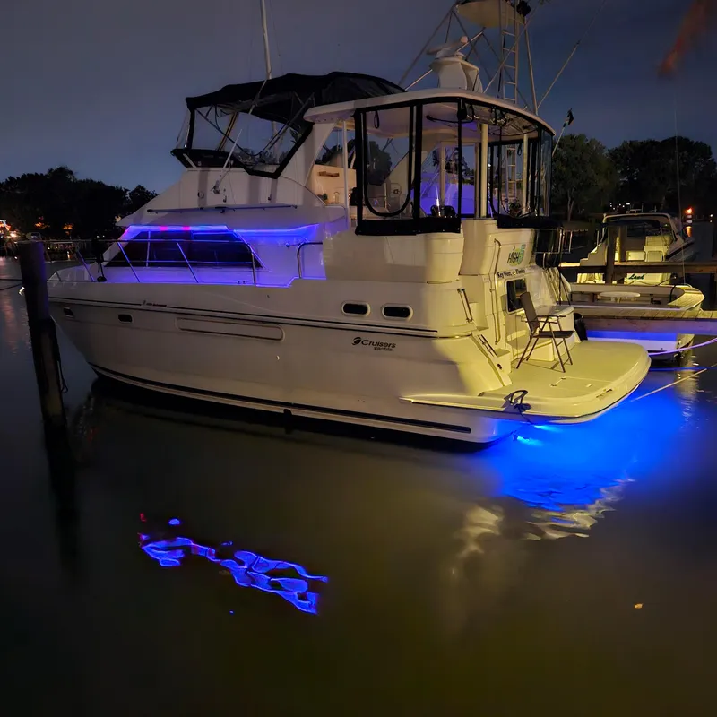 Slide: The Image of 1999 Cruisers Yachts 3750 Motoryacht with blue underwater lights at night. - 12