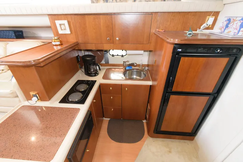 Slide: The Image of 1999 Cruisers Yachts 3750 Motoryacht kitchen with wood cabinetry, sink, stove, and refrigerator. - 21