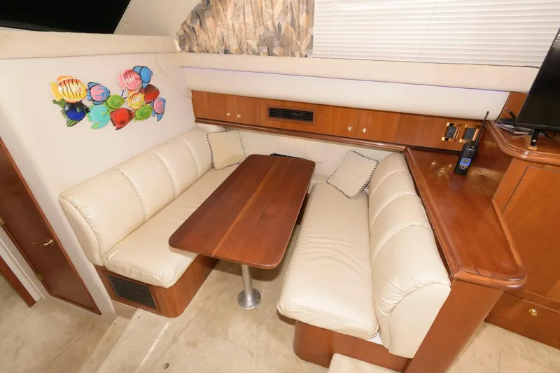 Slide: The Image of 1999 Cruisers Yachts 3750 Motoryacht interior with beige seating and wooden table. - 22