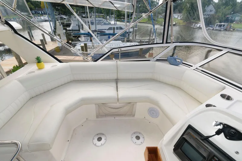 Slide: The Image of 1999 Cruisers Yachts 3750 Motoryacht interior with white seating and marina view. - 9