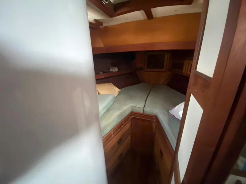 Slide: The Image of Cozy cabin interior of 1983 Shannon 38 sailboat with wooden accents and bedding. - 12