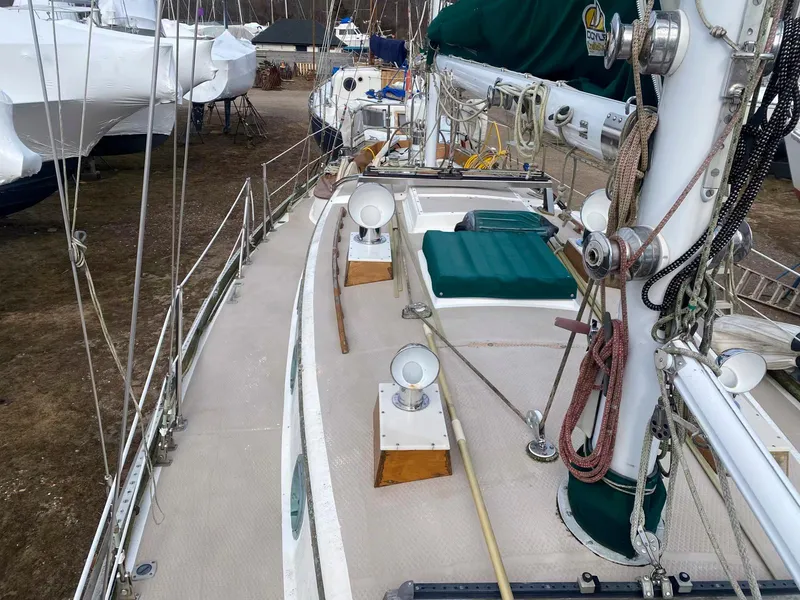 Slide: The Image of 1983 Shannon 38 sailboat deck with green covers and rigging, docked on land. - 14