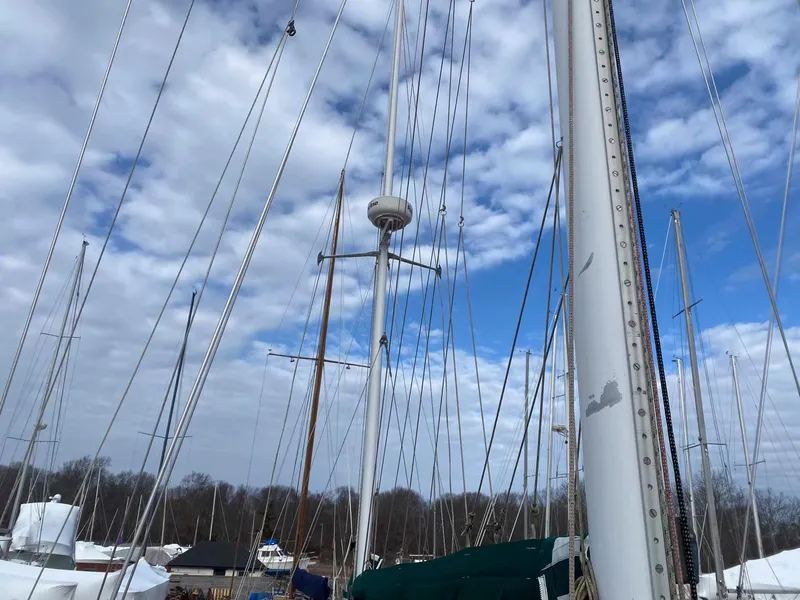 Slide: The Image of Sailboat masts against a cloudy sky, featuring a 1983 Shannon 38 model. - 15