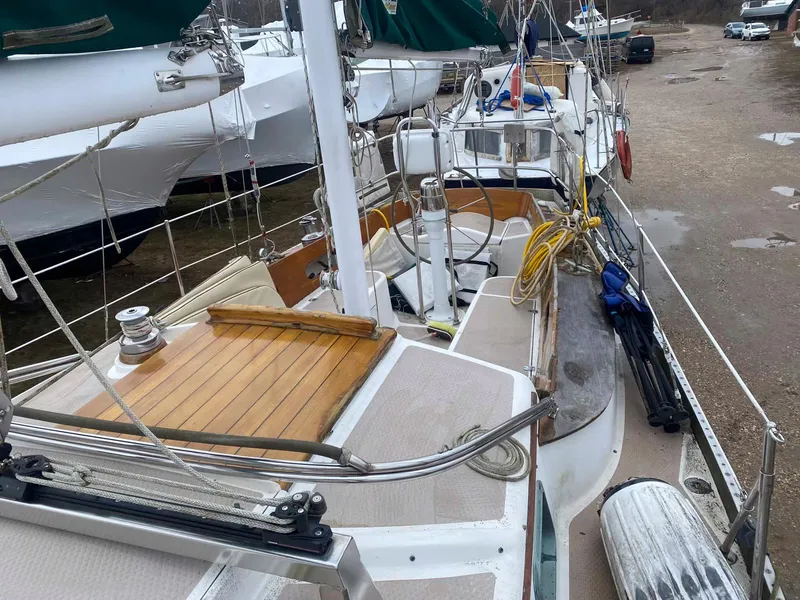 Slide: The Image of 1983 Shannon 38 sailboat on land, showcasing deck and rigging details. - 19