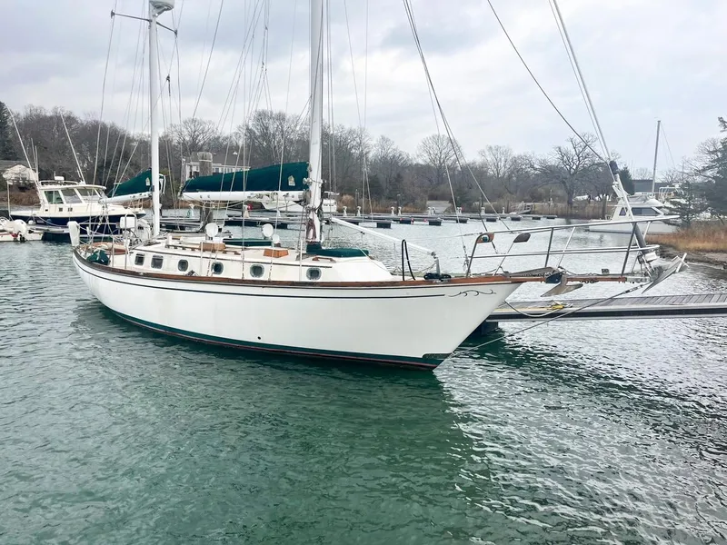 Slide: The Image of Sailboat Shannon 38, 1983 model, docked in a serene marina setting. - 2
