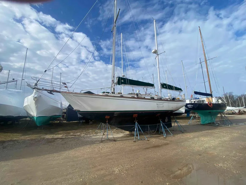 Slide: The Image of 1983 Shannon 38 sailboat on stands, under a partly cloudy sky. - 4
