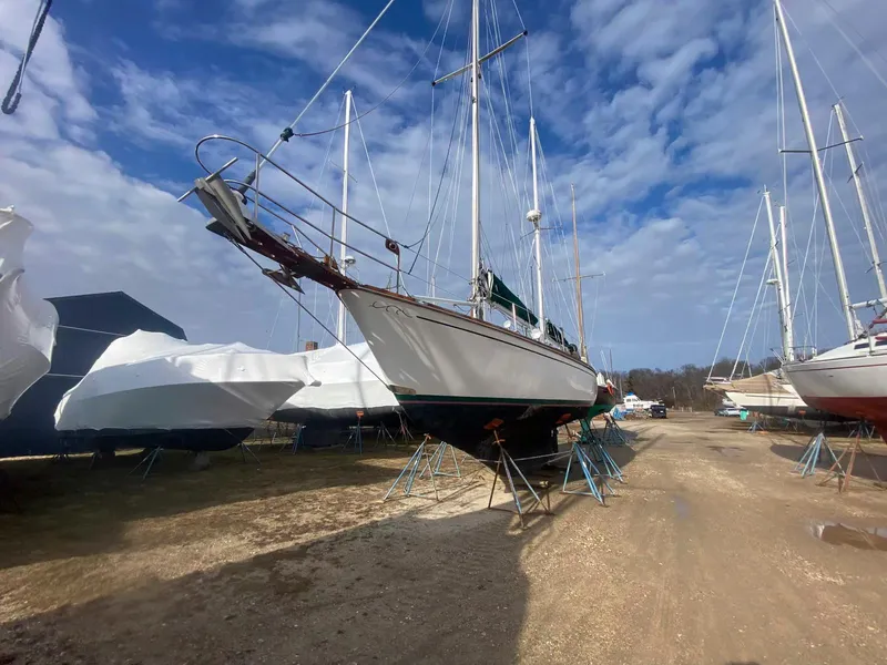 Slide: The Image of 1983 Shannon 38 sailboat on stands in a boatyard under a blue sky. - 5