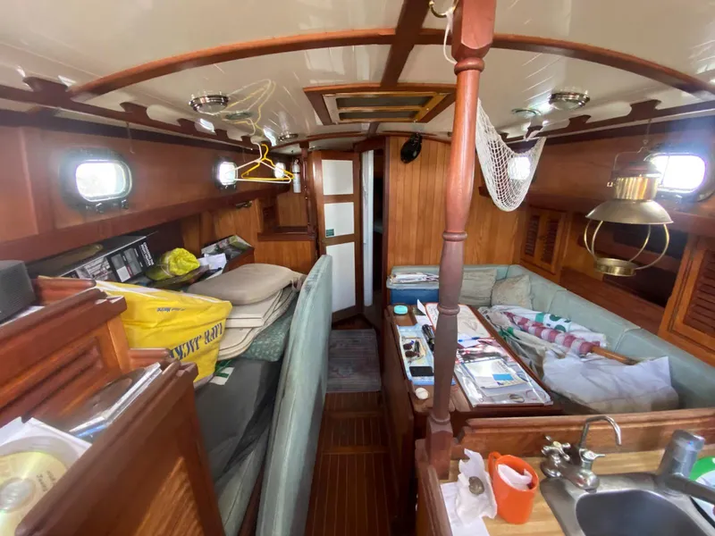 Slide: The Image of Interior of a 1983 Shannon 38 sailboat with cozy wooden furnishings and nautical decor. - 8