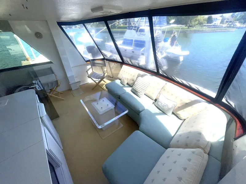 Slide: The Image of Luxurious 1989 Hatteras 80 Cockpit Motor Yacht interior with spacious seating and waterfront view. - 19