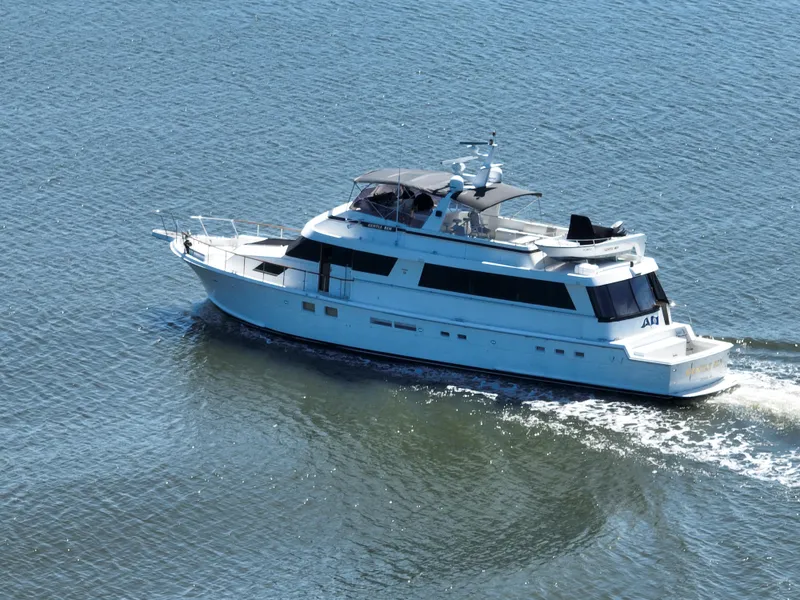 Slide: The Image of 1989 Hatteras 80 Cockpit Motor Yacht cruising on calm waters. - 5
