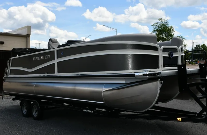 Slide: The Image of 2024 Premier 250 Solaris pontoon boat on trailer under a partly cloudy sky. - 5