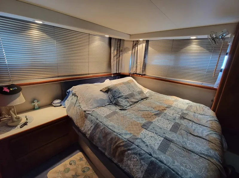 Slide: The Image of Cozy bedroom in 1992 Carver 33 Aft Cabin yacht with patterned bedding and window blinds. - 5
