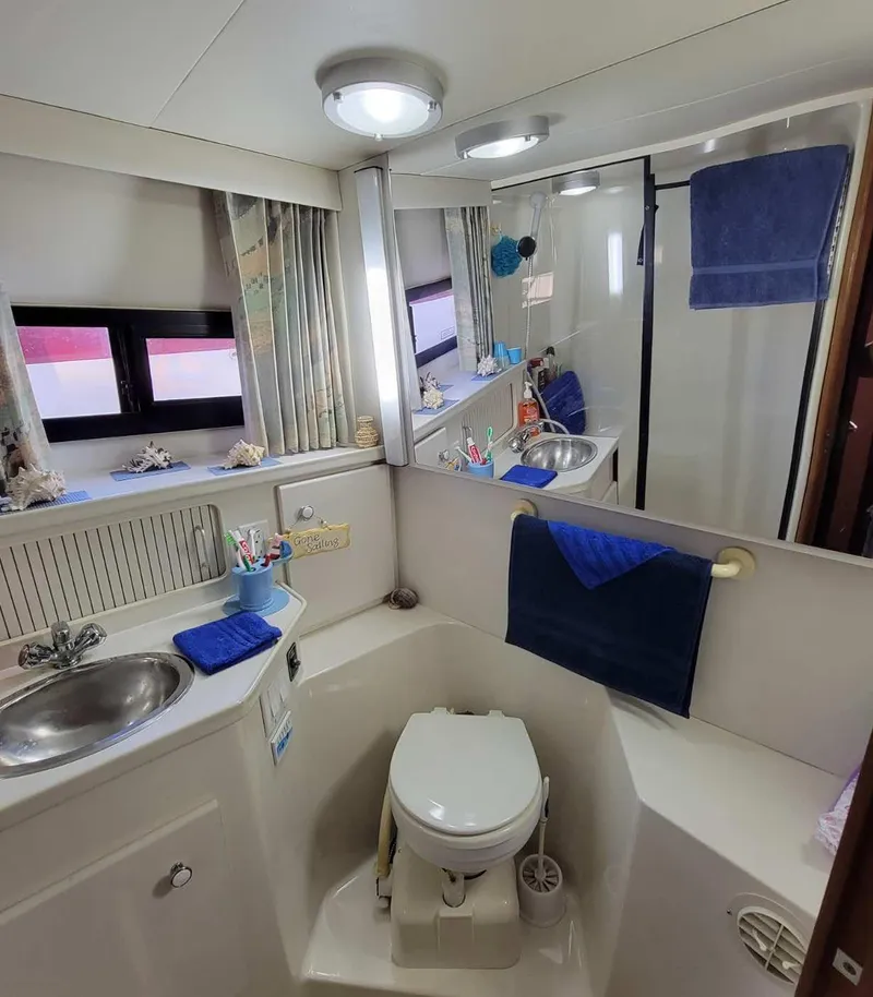 Slide: The Image of 1992 Carver 33 Aft Cabin bathroom with sink, toilet, and mirror. - 7