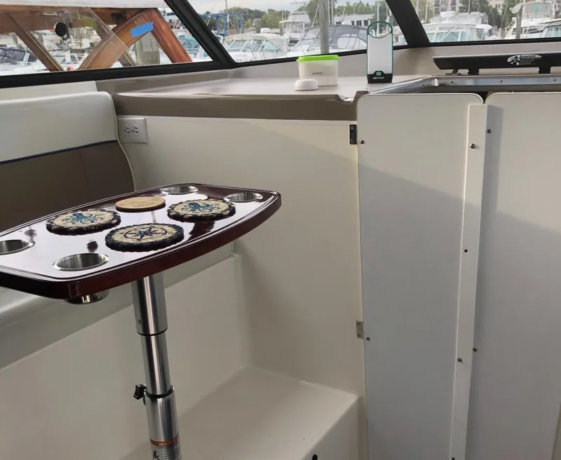 Slide: The Image of 2005 Bayliner 289 Classic interior with table and kitchenette, docked at marina. - 2