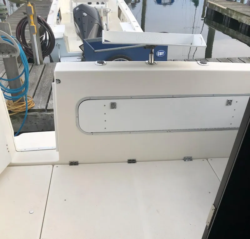 Slide: The Image of 2005 Bayliner 289 Classic boat deck at marina, featuring clean white surfaces and dock equipment. - 3