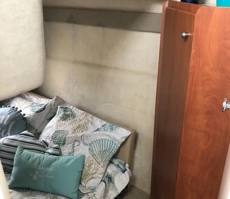 Slide: The Image of Cozy cabin interior of 2005 Bayliner 289 Classic with decorative bedding and wooden cabinet. - 6
