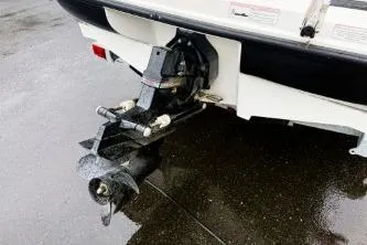 Slide: The Image of 2012 Bayliner 175 Bowrider boat stern and propeller on wet pavement. - 6